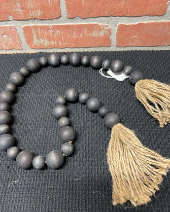 BLACK WOOD BEADS STRUNG ON JUTE WITH TASSEL ENDS