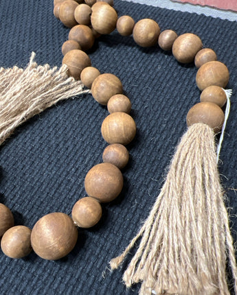BROWN WOOD BEADS STRUNG ON JUTE WITH TASSEL ENDS