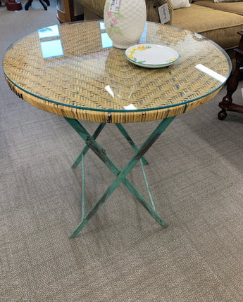 TABLE  WITH ROUND WICKER AND GLASS TOP AND GREEN DISTRESSED FOLDING METAL BASE