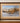 RED FOX IN SNOW, SIGNED & NUMBERED, BROWN WOOD FRAME, WHEAT WOVEN MAT
