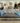 GRAY UPHOLSTERY, CREAM WOOD LEGS, BROWN & RUST PRINT BACK PILLOWS, 2 TEAL TOSS P