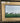 ELONGATED GOLD ORNATE FRAME W/HORSES RUNING ACROSS A MEADOW
